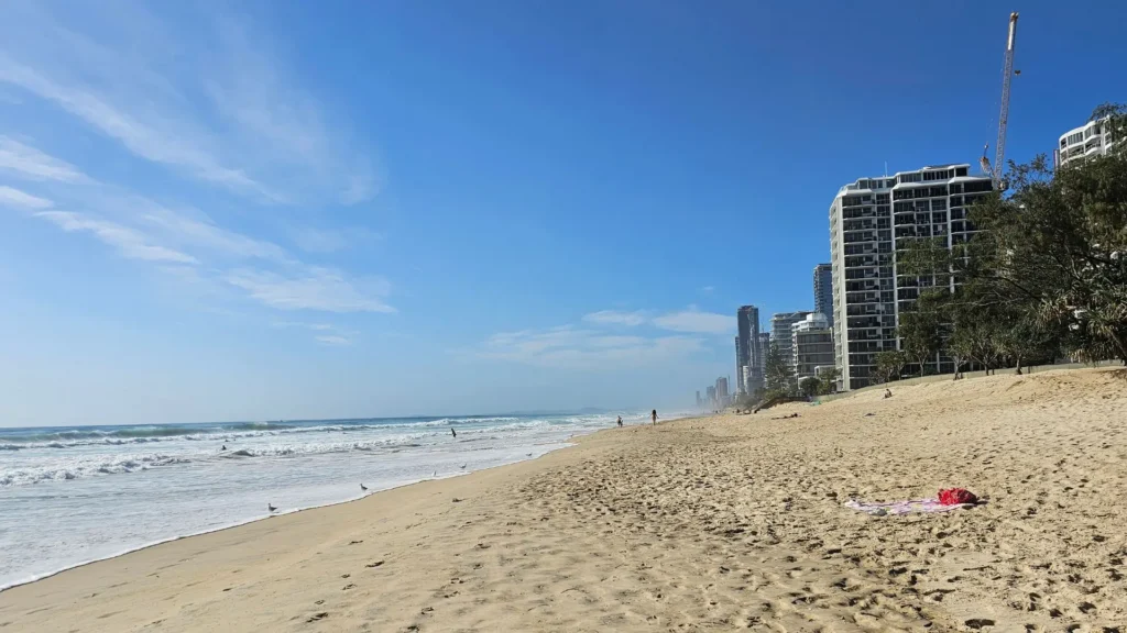 Main Beach Southport Gold Coast sandy shoreline looking north toward high-rise apartments and gentle surf