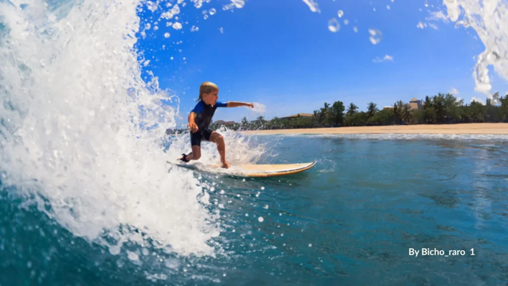 Beginner surfing Queensland β young surfer catching a wave on a soft-top board