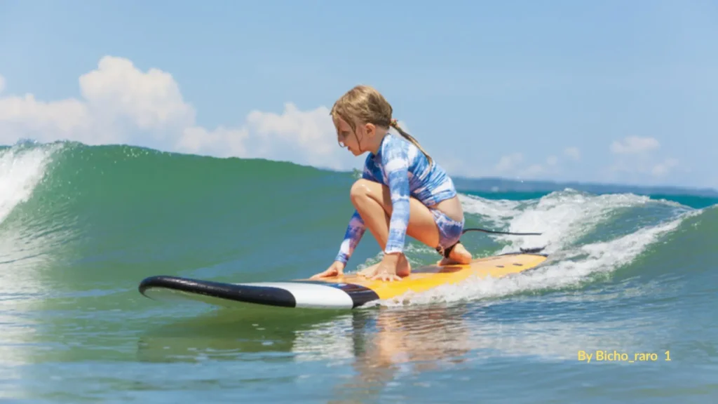 Beginner surfing Queensland β young girl riding a gentle wave on a soft-top board