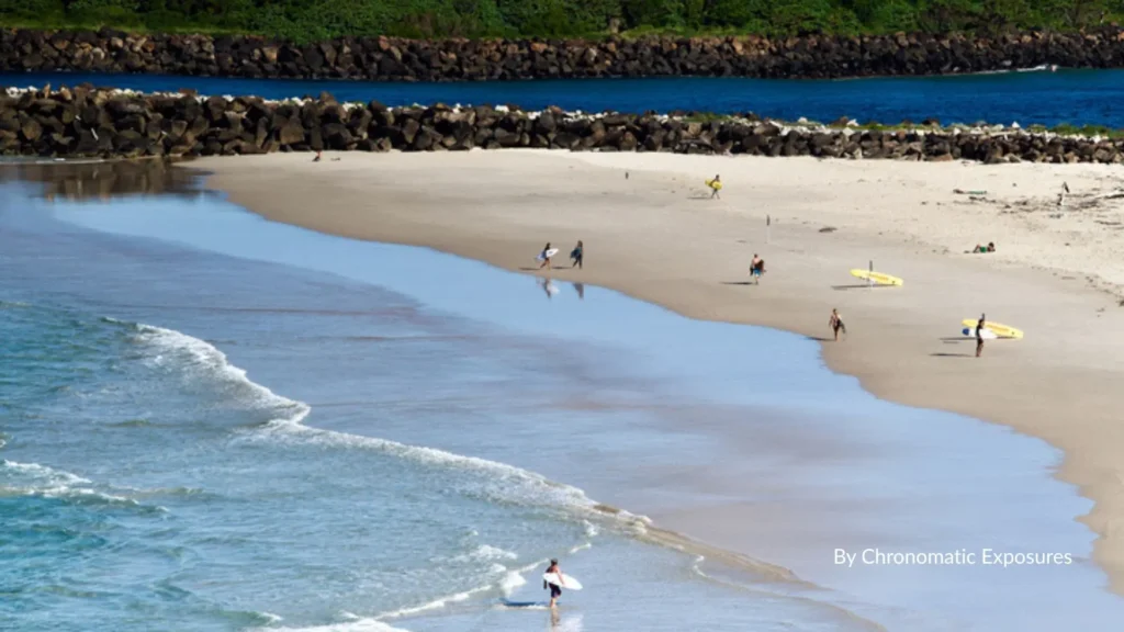 People walking and surfing on the sandy shore at Duranbah Beach