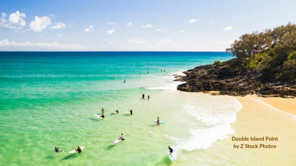 Beginner surfing Queensland β aerial view of a calm sandy beach with learners in the water